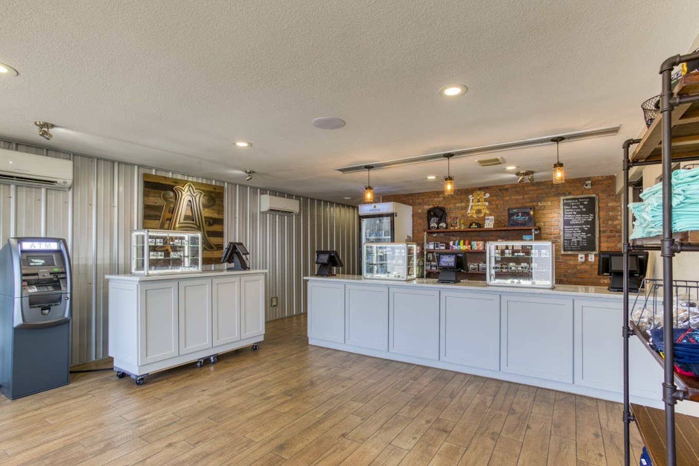 Apothecary Farms Pueblo sales floor with display cases, brick wall menu board and merch