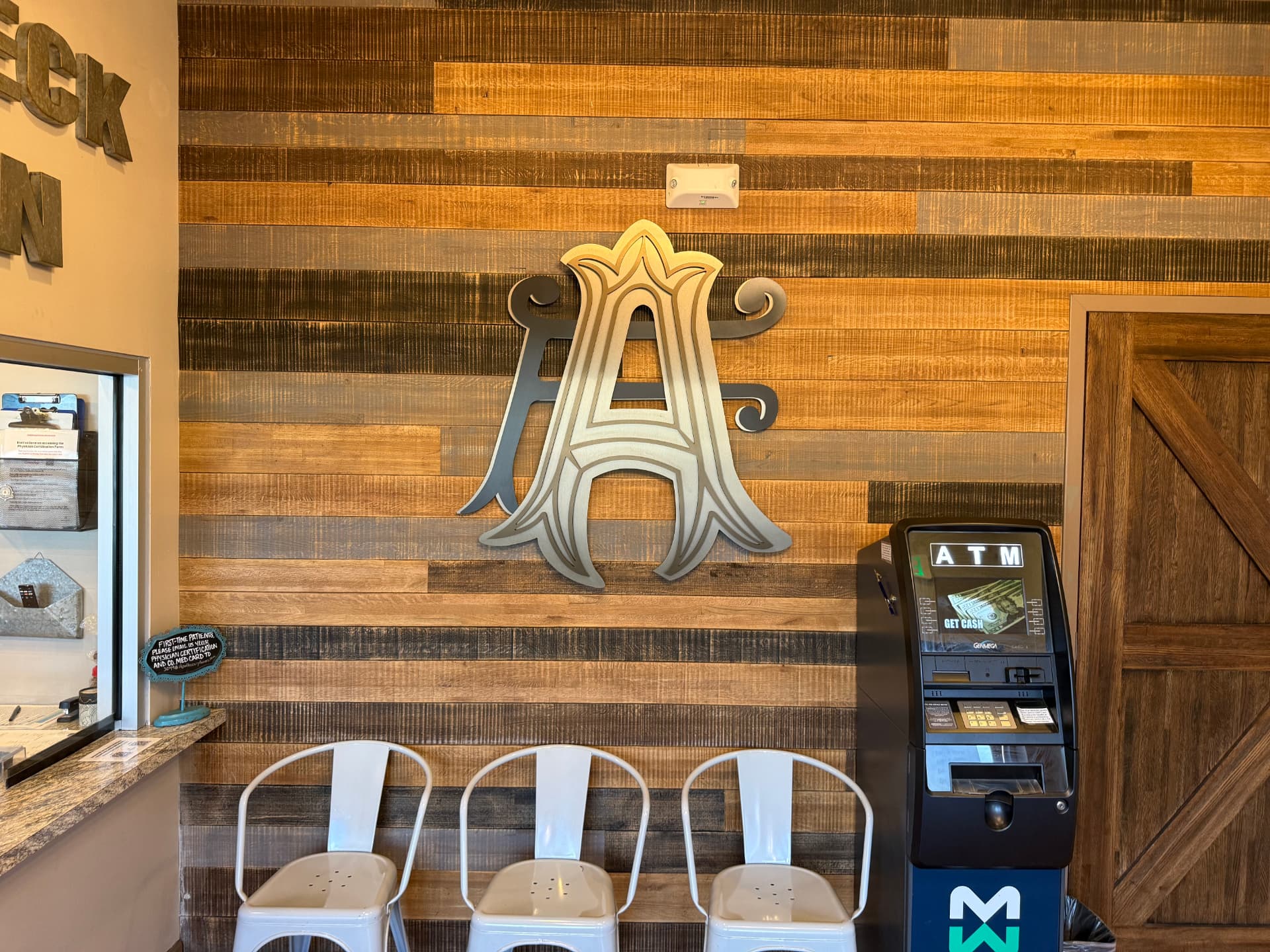 Apothecary Farms Delta Drive lobby with reclaimed wood check-in wall and gold AF monogram